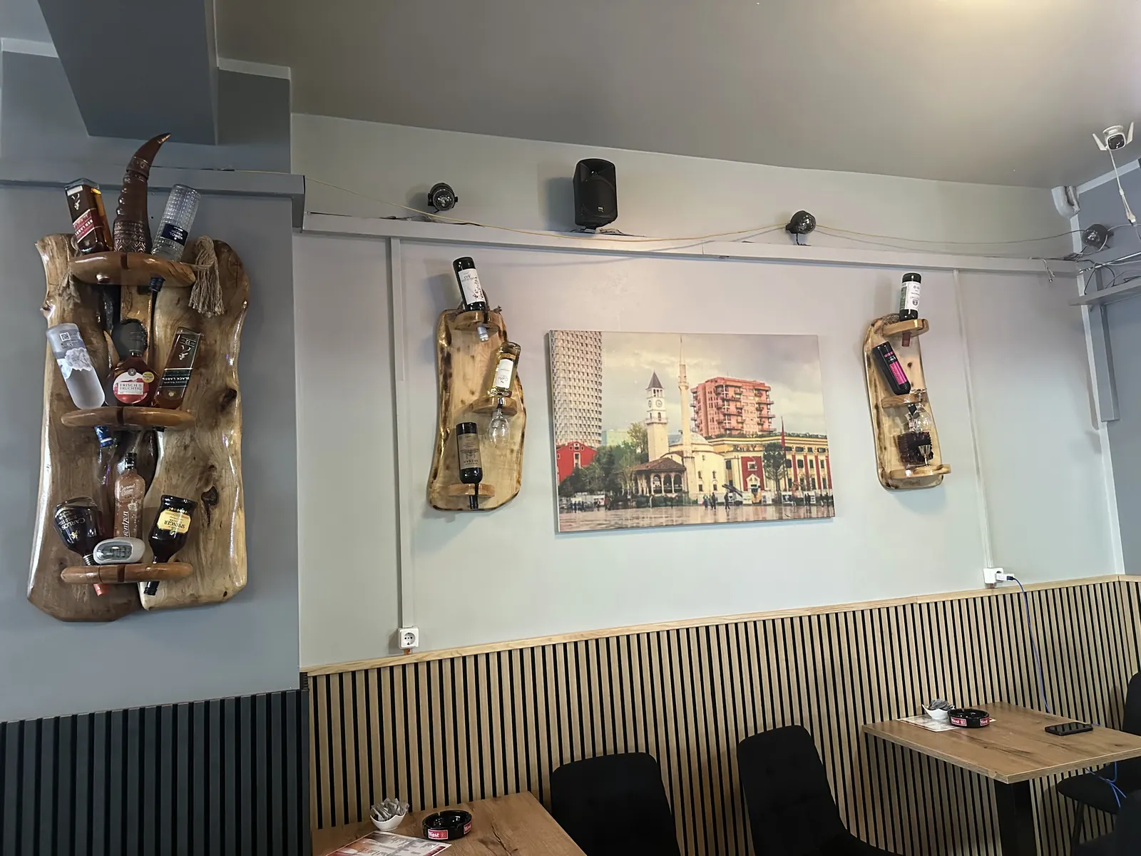 Wand in der Tirona Bar: Bild vom Skanderbeg-Platz in Tirana zwischen Flaschenbrettern aus Holz